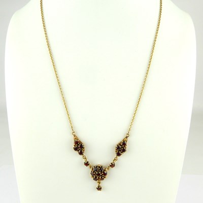 Lot 874 - A 9ct gold claw set garnet cluster necklace on...