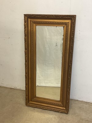Lot 647 - A gilt framed wall mirror with bevelled plate....