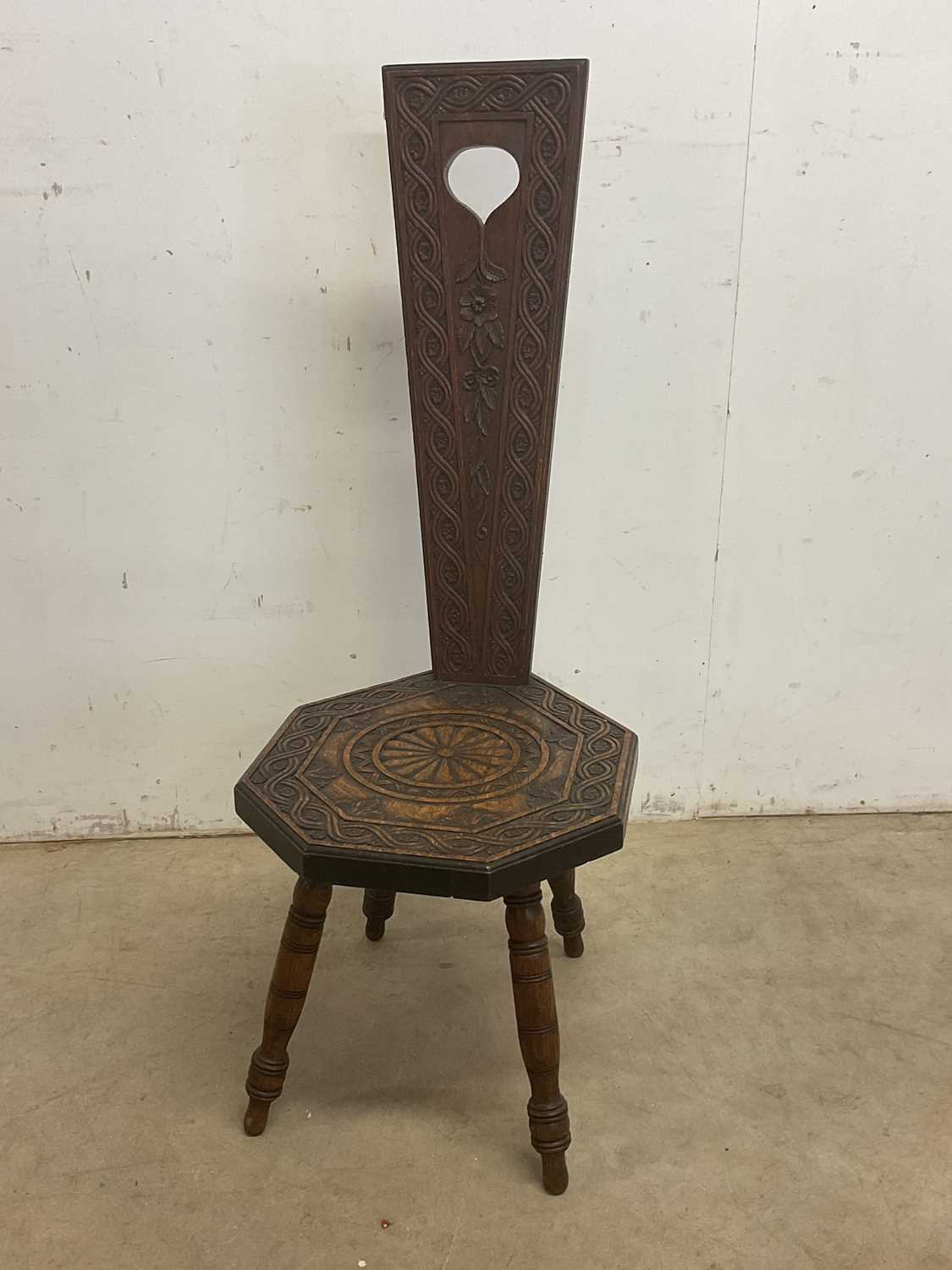 Lot 657 - A carved oak spinning chair with shaped seat...