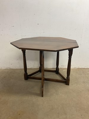 Lot 606 - A hexagonal oak drop-leaf table raised on ring...