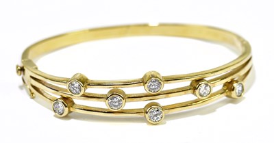 Lot 189 - A yellow metal hinged snap bangle set with...