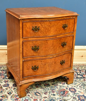 Lot 2586 - A 1950s walnut serpentine front chest of three...