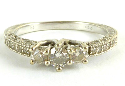 Lot 815 - A 9ct white gold three-stone diamond ring,...