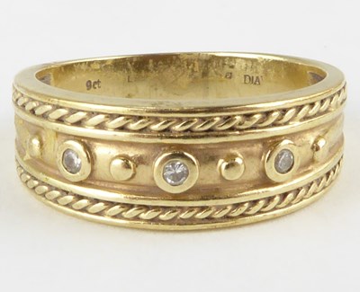 Lot 825 - A 9ct gold ring, the top with centred row of...