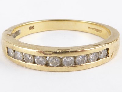 Lot 823 - A 9ct gold half eternity ring with nine small...