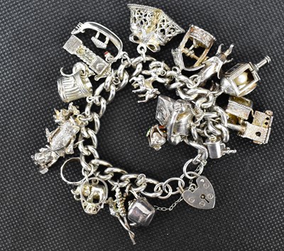 Lot 849 - A hallmarked silver charm bracelet, united...