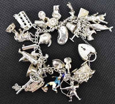 Lot 850 - A hallmarked silver charm bracelet united with...