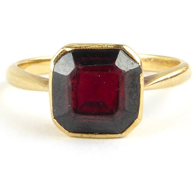 Lot 802 - A 22ct gold ring with square bezel set red...