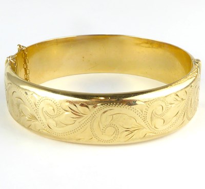 Lot 840 - A 9ct gold hollow hinged bracelet with safety...