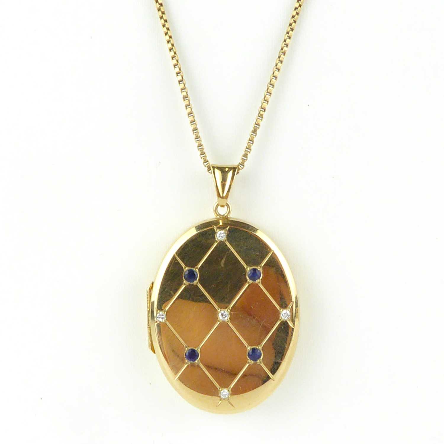 Lot 879 - A 9ct gold oval double locket pendant with a