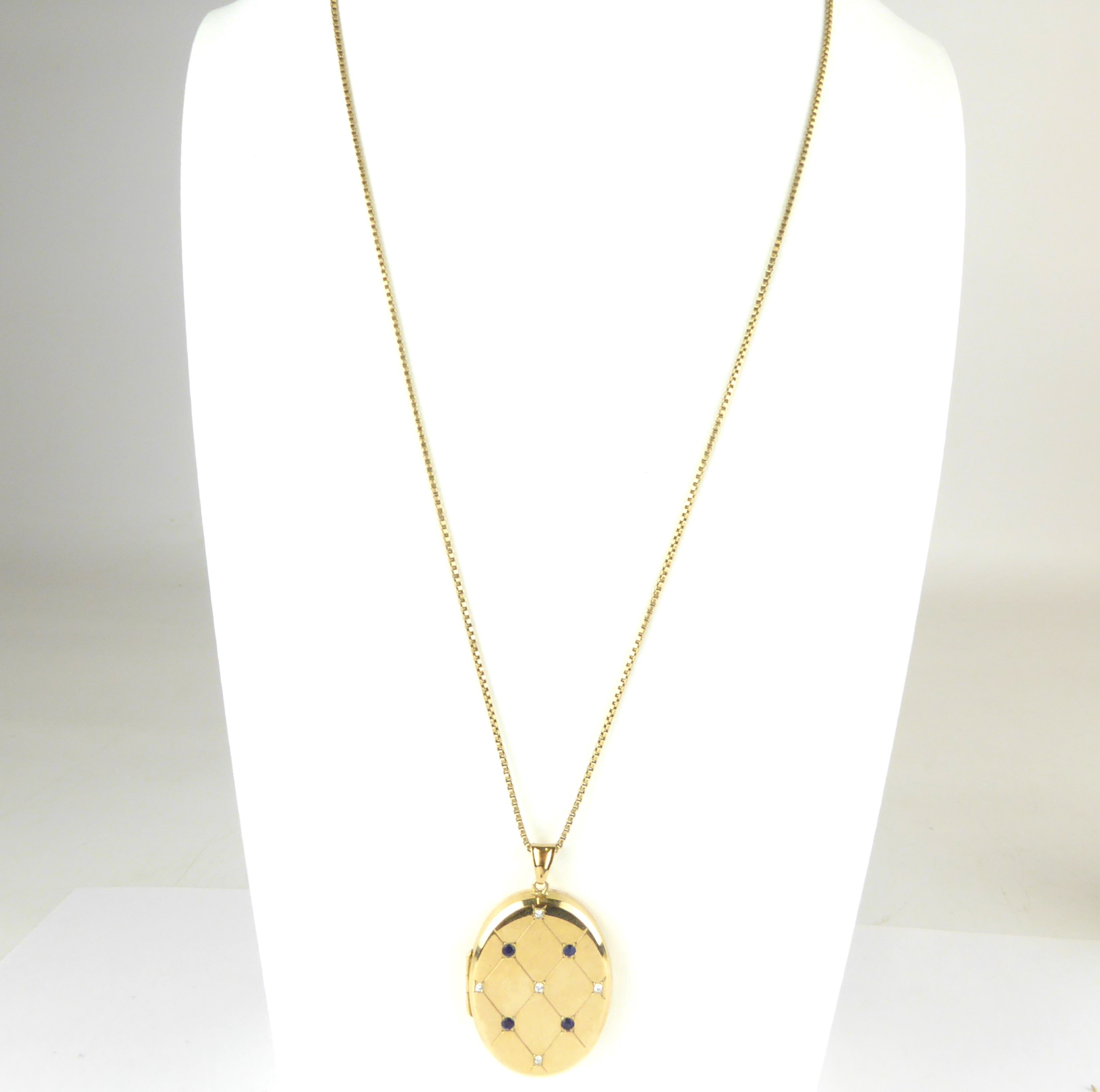 Lot 879 - A 9ct gold oval double locket pendant with a