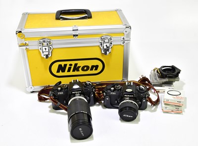 Lot 2162 - NIKON; a travelling case containing two FE2...