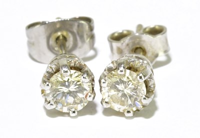 Lot 320 - A pair of white metal diamond ear studs, each...