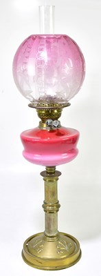 Lot 2329 - An early 20th century oil lamp, the cranberry...