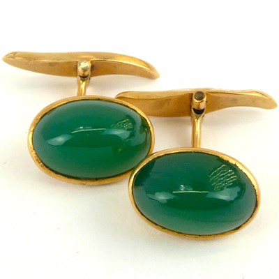 Lot 1097 - A pair of 9ct gold cufflinks set with green...