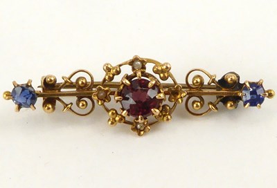 Lot 1051 - A 14ct gold bar brooch with central cut red...