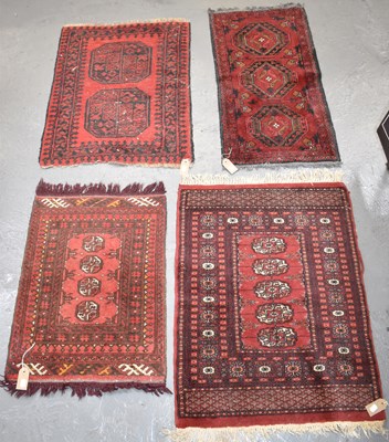 Lot 94 - Four small hand knotted woollen red ground rugs.