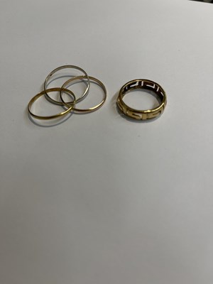 Lot 777 - A yellow metal ring, together with three...