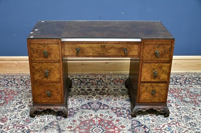 Lot 2391 - A 1930's walnut kneehole desk, with an...