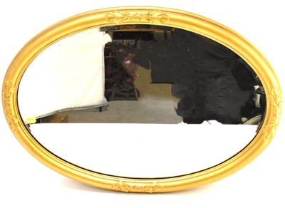 Lot 108 - A large oval bevel edged mirror in a gilt wood...