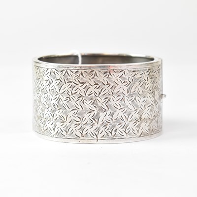 Lot 1034 - A hallmarked silver hinged bracelet with...