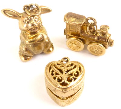 Lot 1107 - Three 9ct gold charms comprising rabbit, steam...