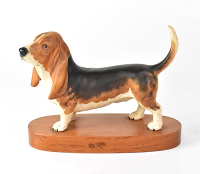 Lot 451 - BESWICK; a figure of a Basset hound on wooden...