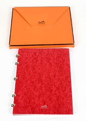 Lot 773 - HERMÈS; a red marbled card ring binder...