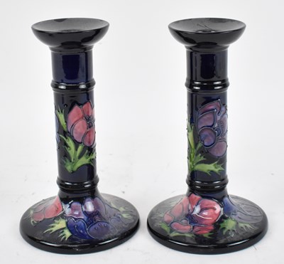 Lot 425 - MOORCROFT; a pair of blue ground candlesticks...