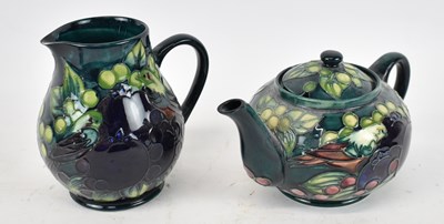 Lot 441 - MOORCROFT; a green ground teapot decorated in...