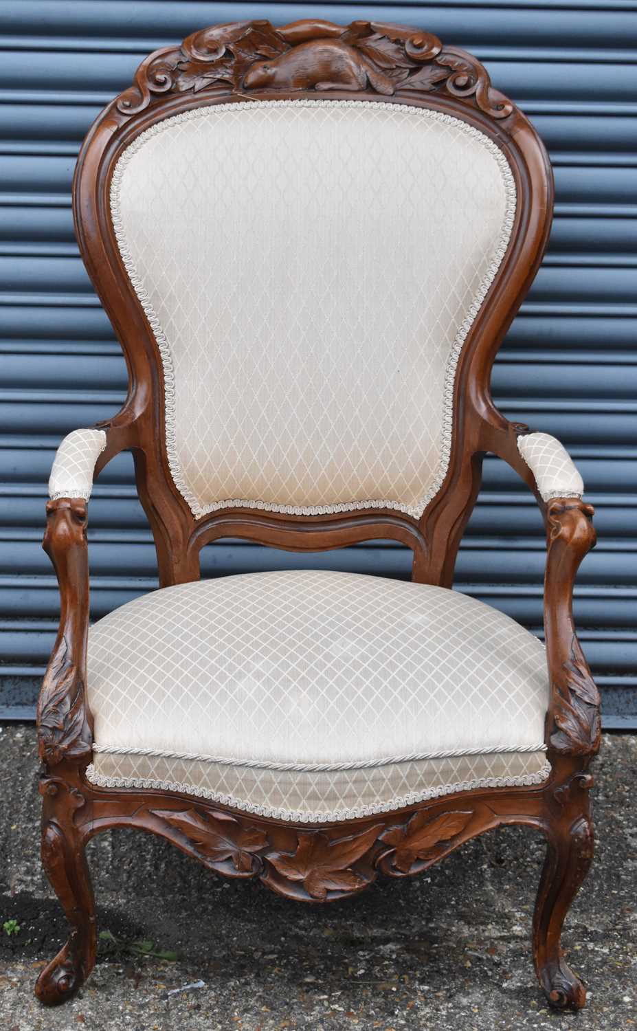 Lot 10 - A spoon back open arm chair, the wooden frame...