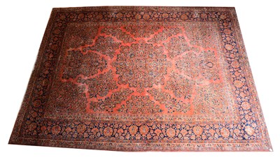 Lot 135 - A large red ground hand knotted carpet with...