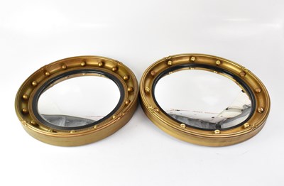 Lot 119 - A near-pair of gilded circular wall mirrors...