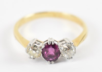 Lot 673 - An 18ct gold three stone ring, the central...