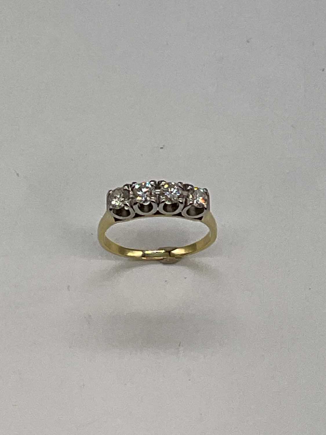 Lot 1156 - A 18ct yellow gold four stone diamond ring,...