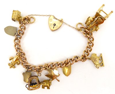 Lot 1018 - A 9ct gold charm bracelet with nine gold...