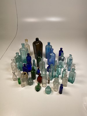 Lot 61 - A quantity of glass bottles, a brass kettle on...