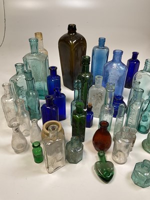 Lot 61 - A quantity of glass bottles, a brass kettle on...