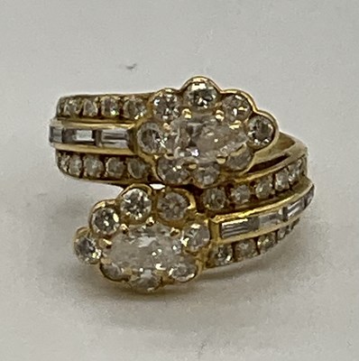 Lot 373 - A yellow metal and diamond set crossover ring,...