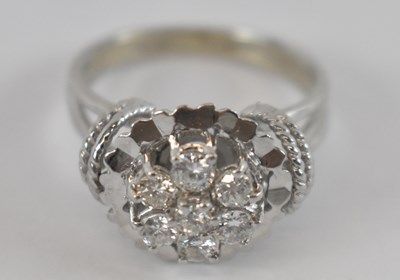 Lot 704 - A white metal seven stone diamond cluster ring,...