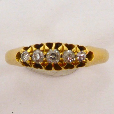 Lot 1010 - An 18ct gold ring with a row of five graduated...