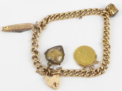 Lot 1016 - A 15ct gold charm bracelet with four charms,...