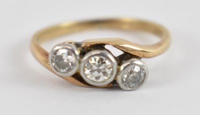 Lot 768 - A yellow metal and three stone diamond ring,...