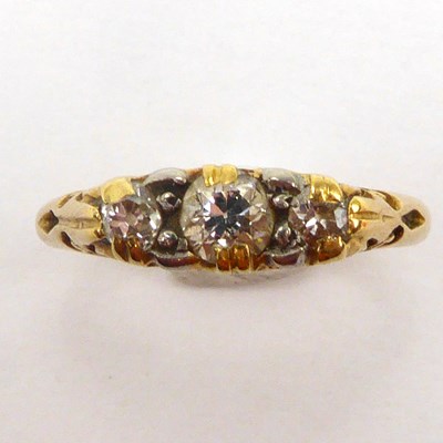 Lot 1005 - An 18ct gold three-stone diamond ring, size M,...