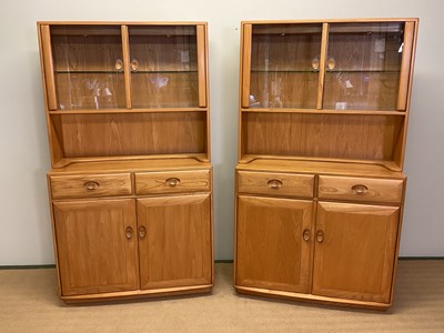 Lot 388 - ERCOL; a pair of elm glazed display cabinets...