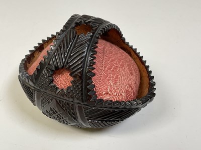 Lot 31 - A carved coconut shell in the form of a basket.