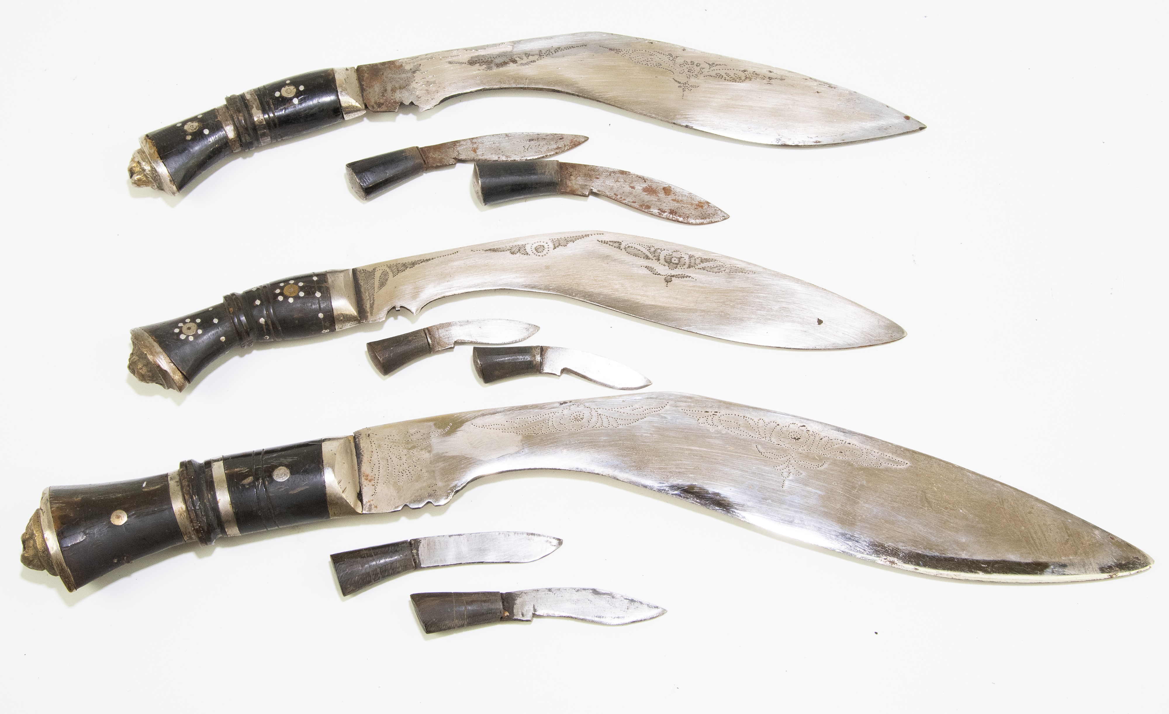 Lot 710 - Three kukri daggers in leather scabbards