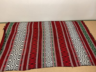 Lot 130 - An African blanket decorated in shades of red,...