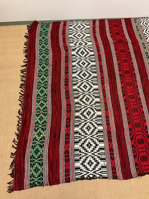 Lot 130 - An African blanket decorated in shades of red,...