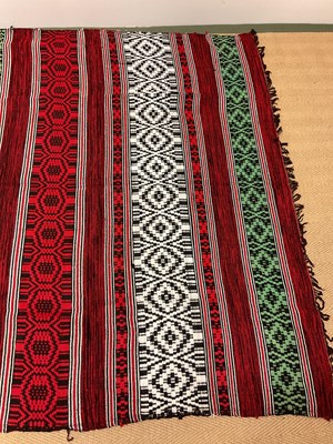 Lot 130 - An African blanket decorated in shades of red,...